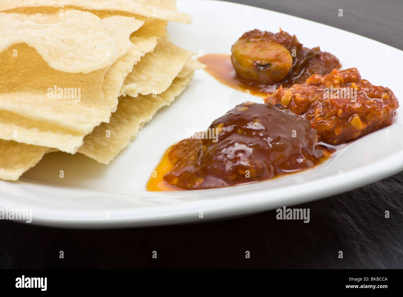 Traditional indian hors d'oeuvre of popadom and spicy pickles. Stock Photo