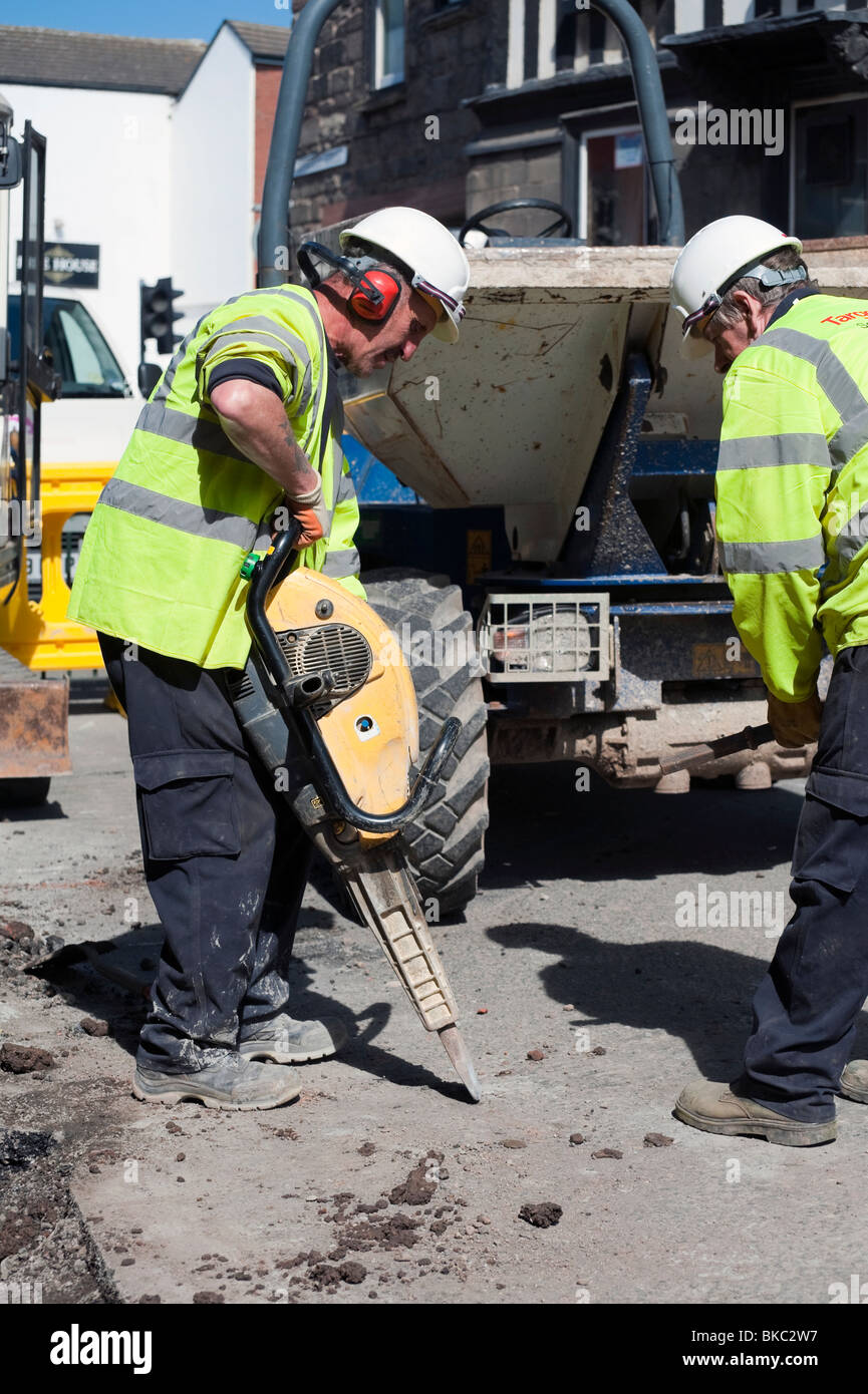 Workmen using a petrol powered pneumatic drill, UK. Work men with hard