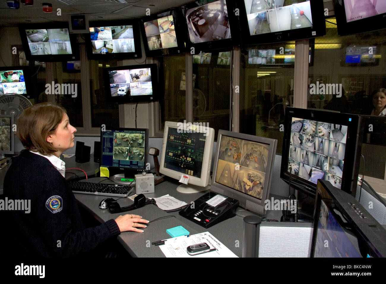 Jail Security Control Room With Female Officer Using Video