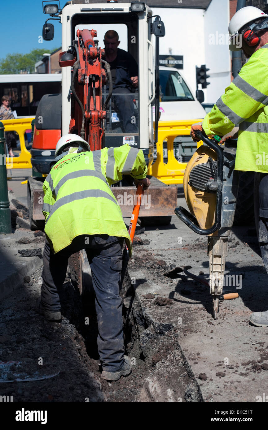 Workmen using a petrol powered pneumatic drill, UK. Work men with hard