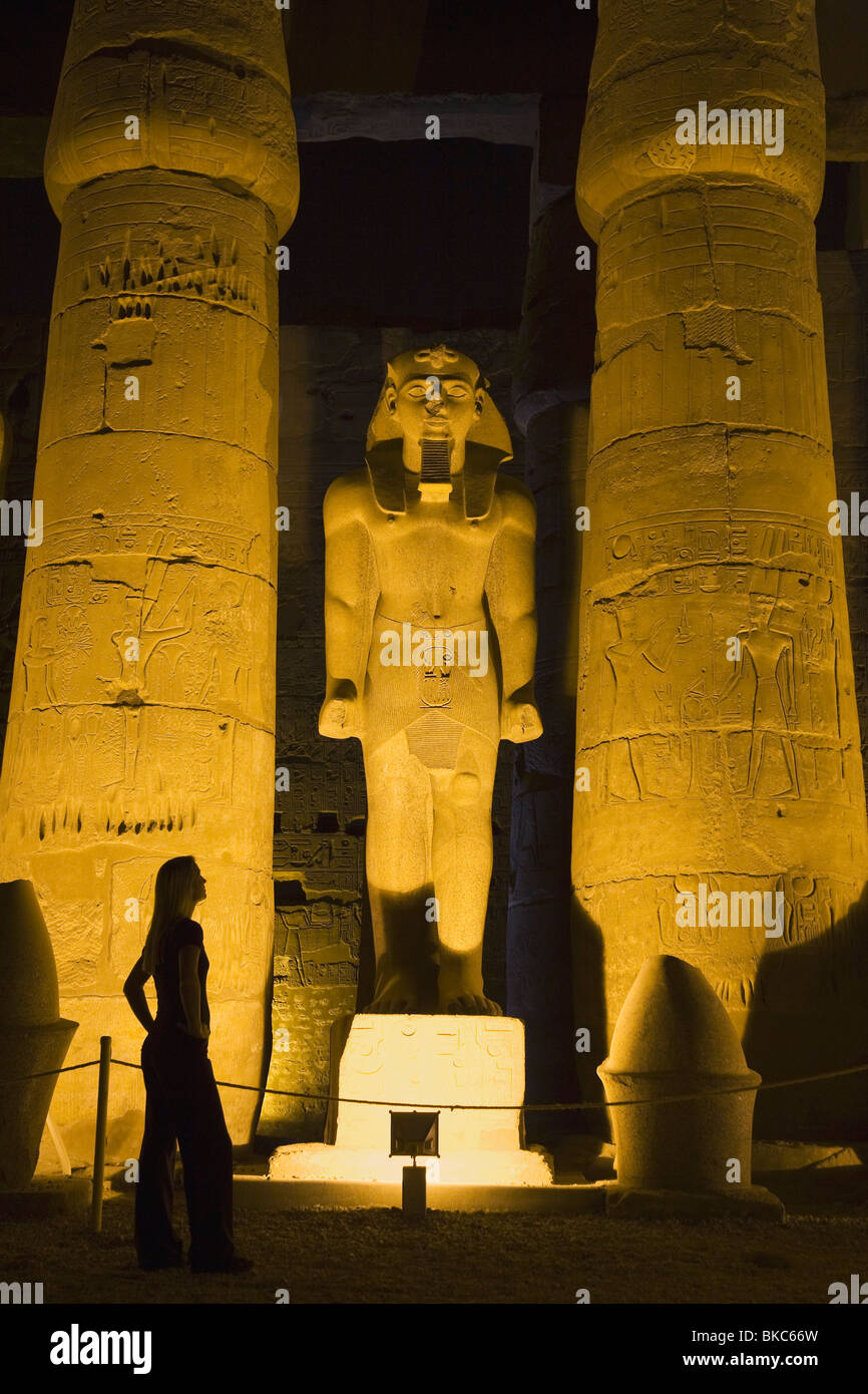 Woman Tourist Admiring Statue Of Ramses In Luxor Temple At Night, Egypt ...