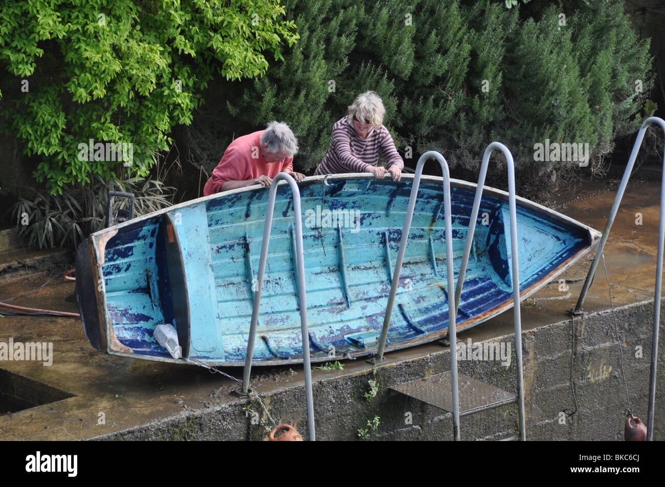 A Island couple prepare their boat on Eel Pie Ishand Twickenham London England Stock Photo