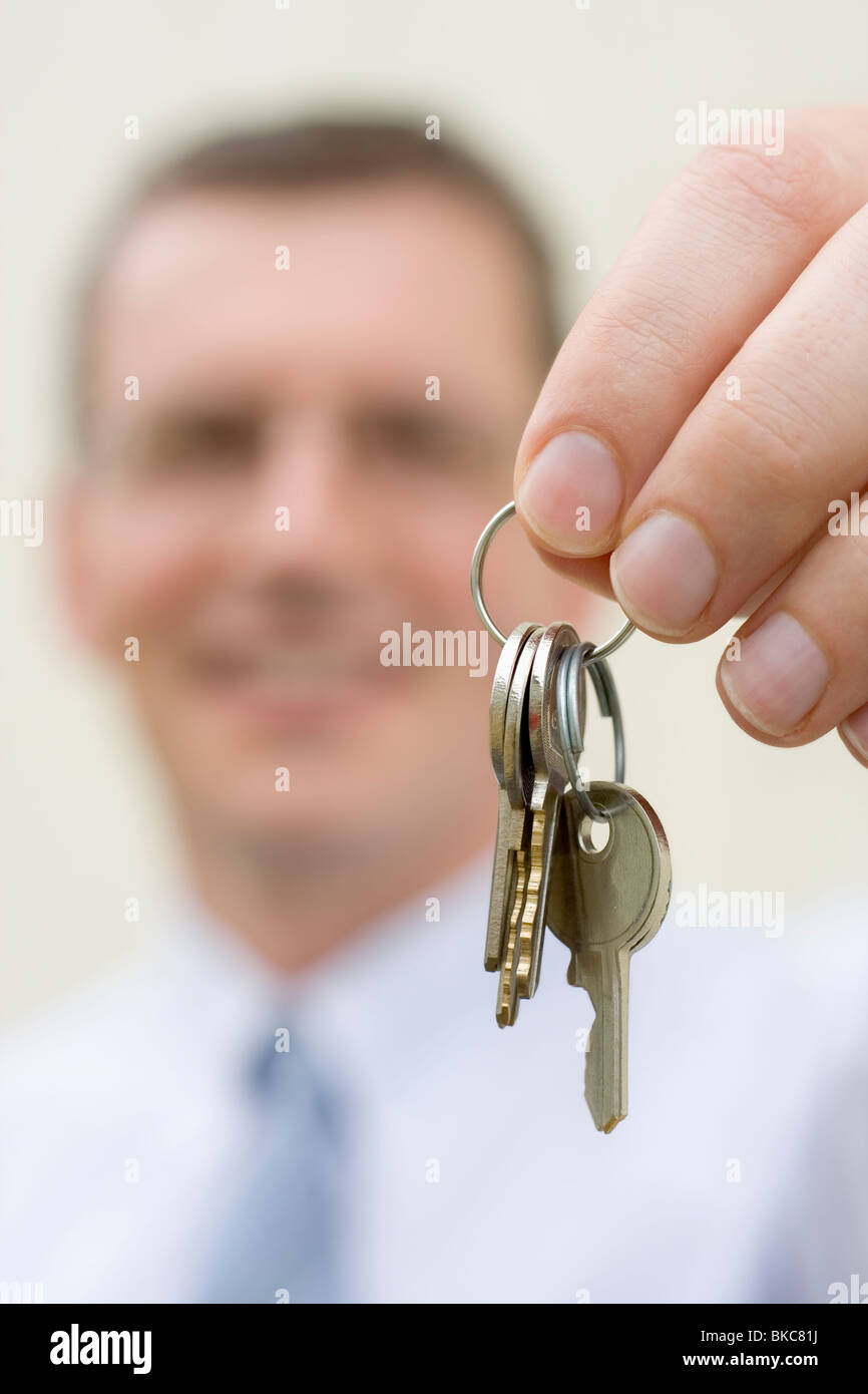 Smiling businessman handing over keys Stock Photo