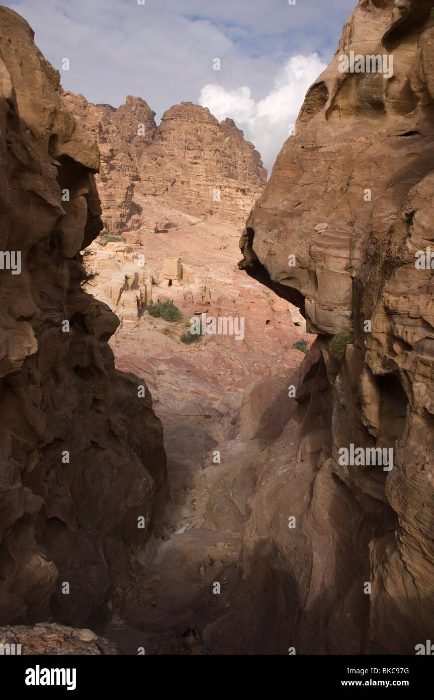 Vista between rocks to Nabataean tombs near Snake Monument. Petra. Jordan Stock Photo