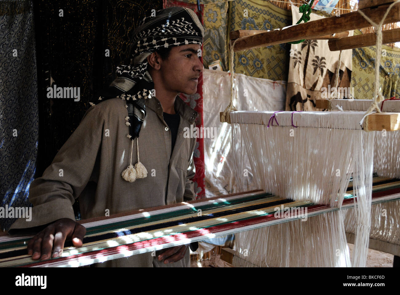 Young Bedouin man weaving inside tent Stock Photo
