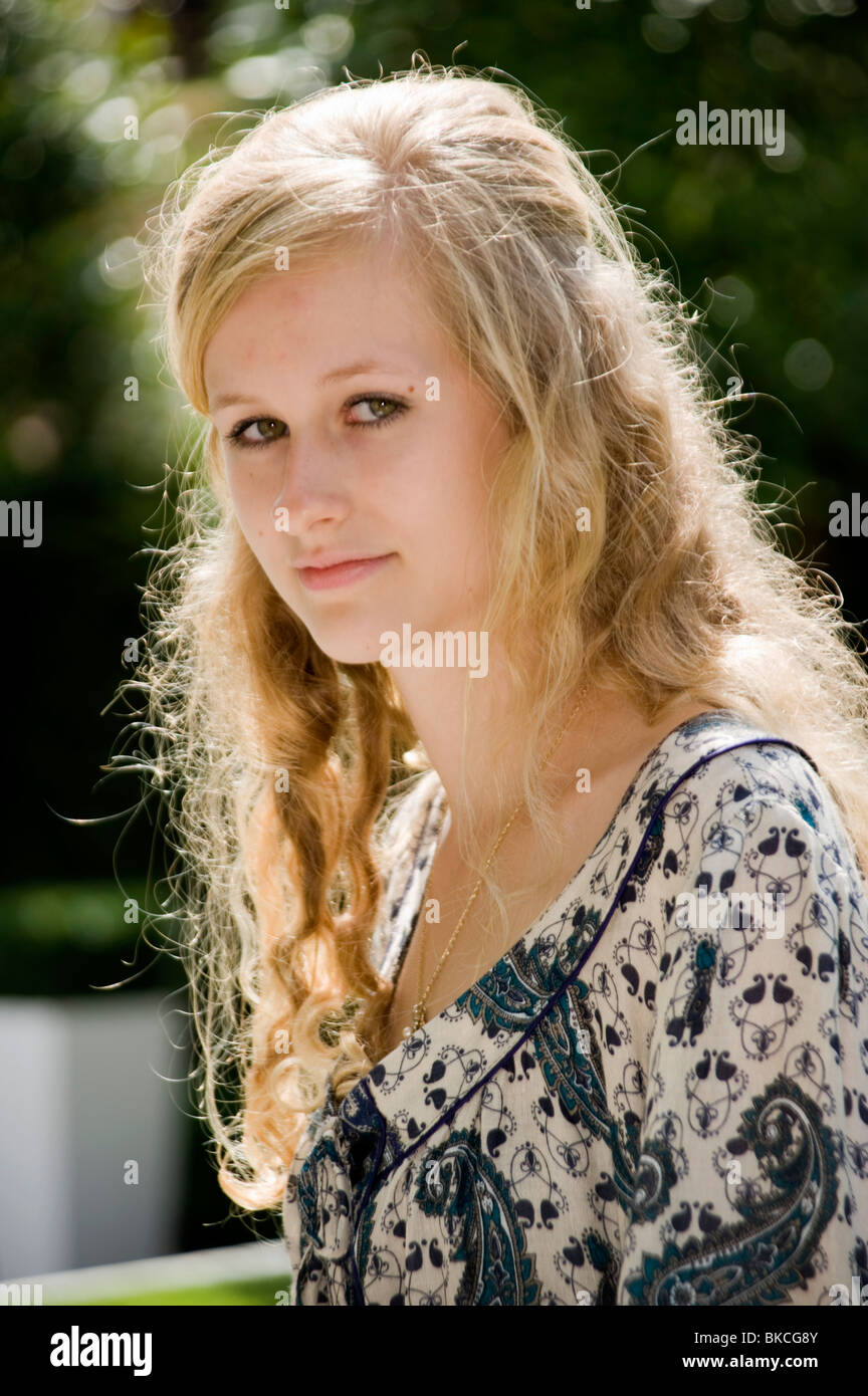 Portrait Of A Blonde Teenage Girl With Curly Hair And Green Eyes