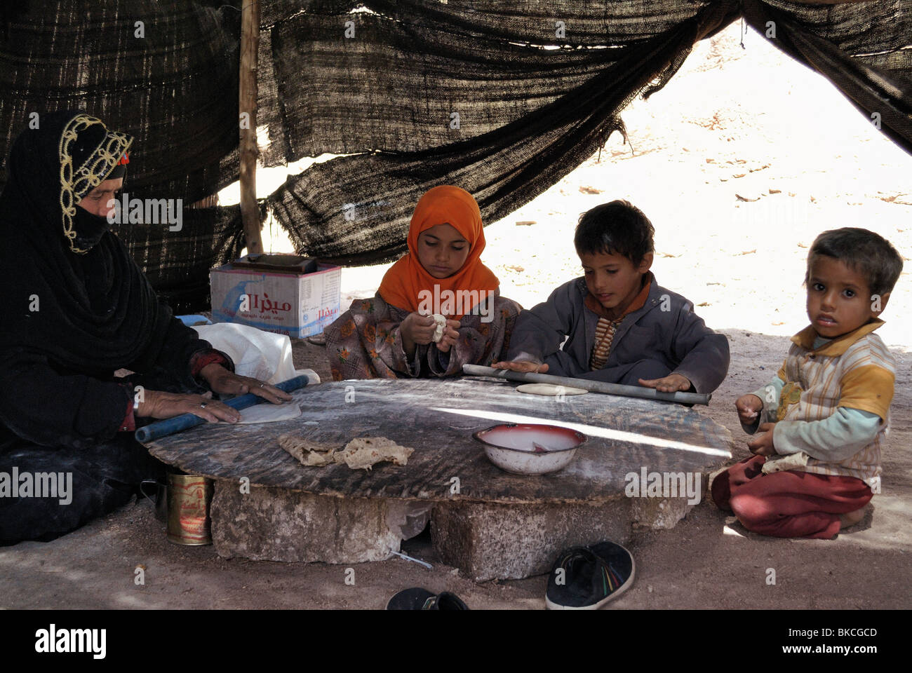 Bedouin women and children making bread inside tent Stock Photo