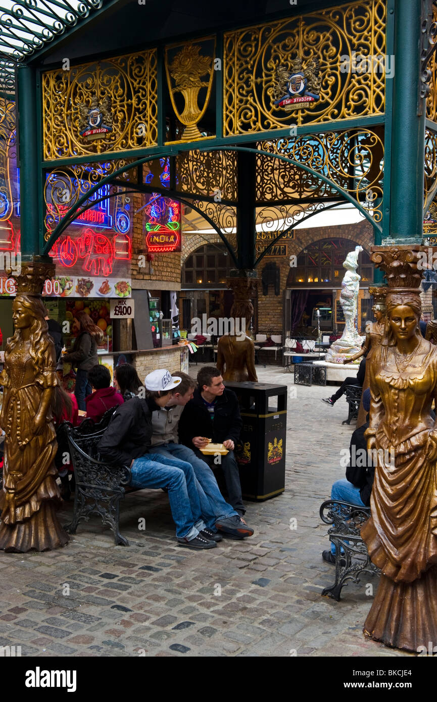 group of young people seated at the Horse Hospital Stables market part of Camden market North London UK Stock Photo