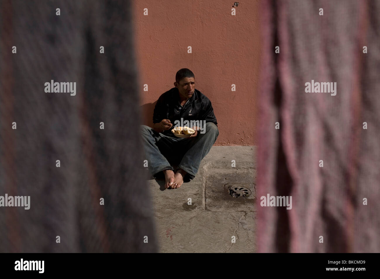 An undocumented Central American migrant traveling across Mexico to reach United States eats in a shelter in Mexico City Stock Photo