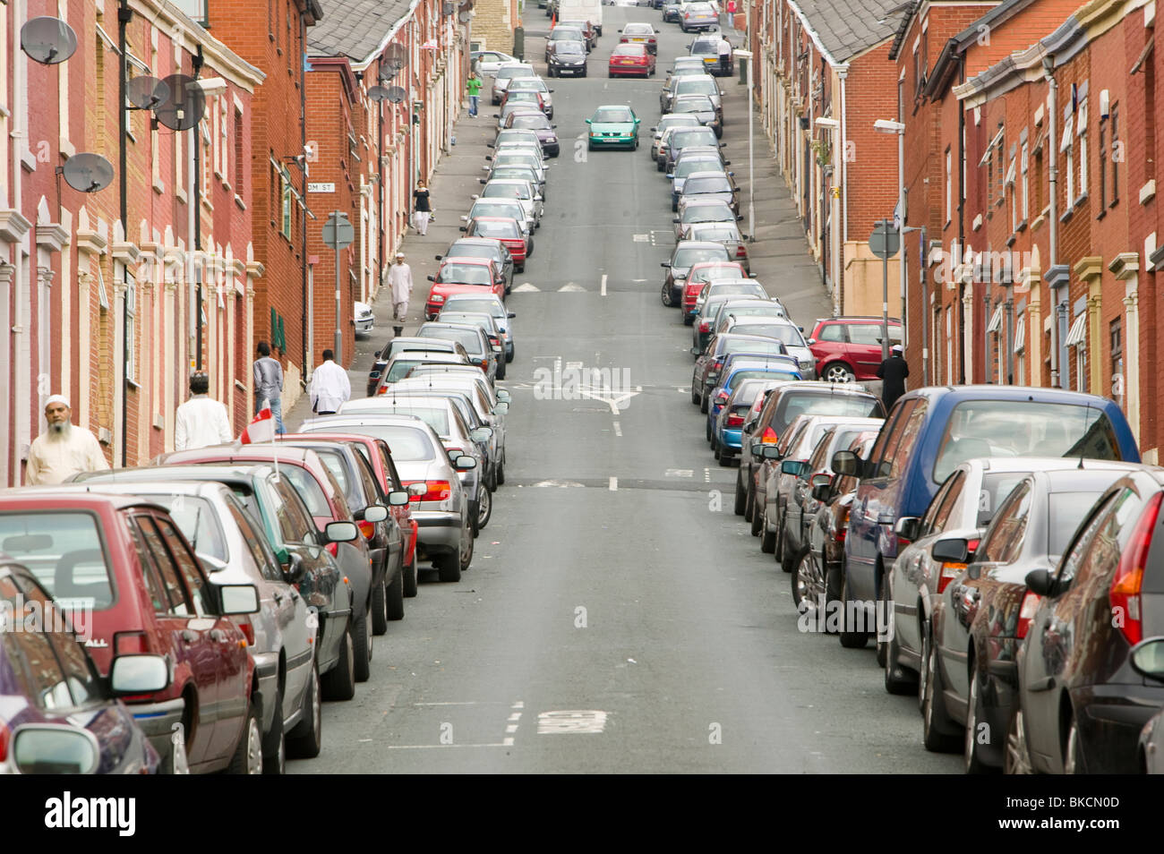 Cars parked on a street in the Asian area of Blackburn UK Stock Photo
