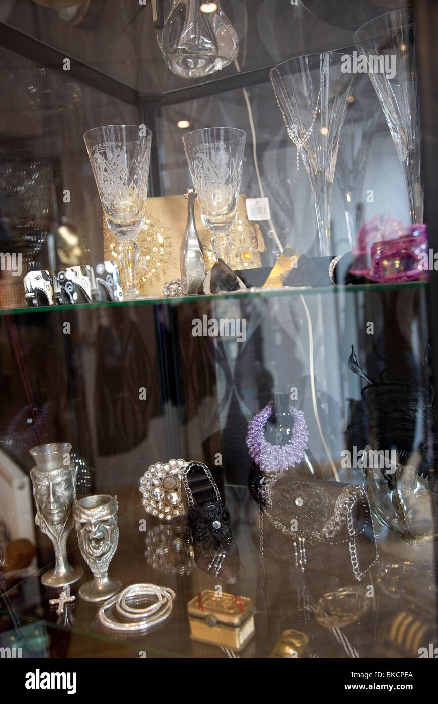 Glass with glasses trinkets and jewelery in Charity Shop Stock