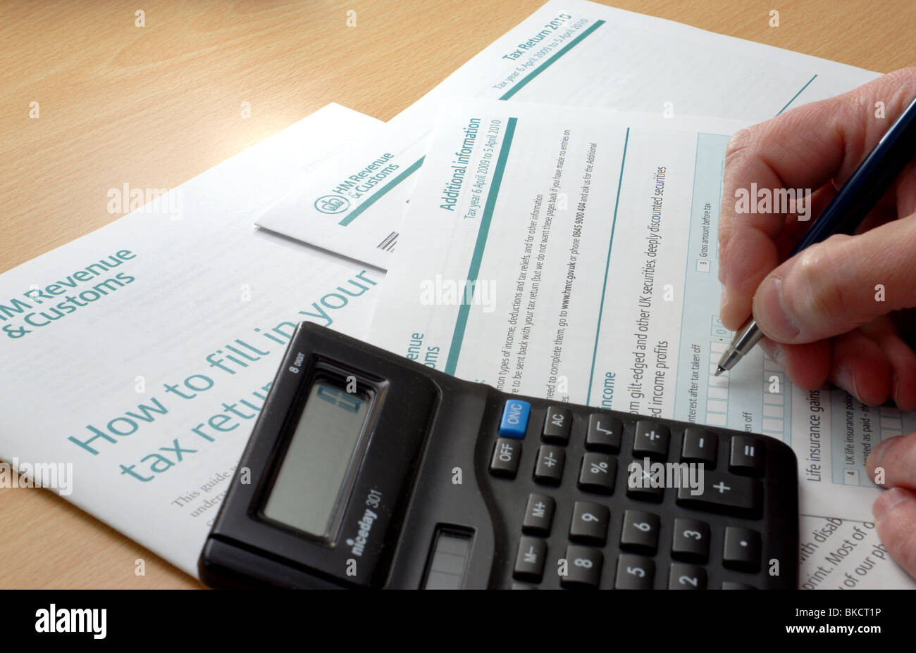 Starting the painful process of completing a tax return.  Ready with pen and calculator to fill in the Additional Information Stock Photo