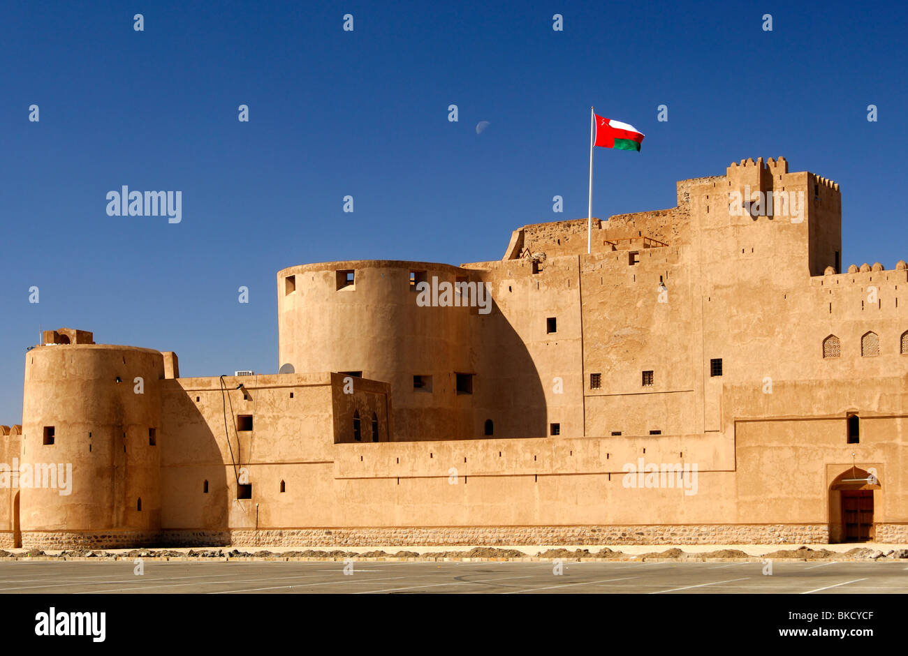 National flag of Oman fluttering over the Jabrin castle, historic adobe fort in the Dhakiliya Region, Sultanate of Oman Stock Photo