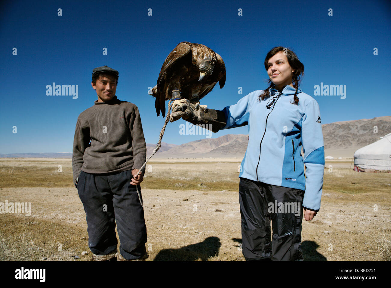 Traveller girl holding a trained hunting bird (berkut, a golden eagle) in western Mongolia. Stock Photo