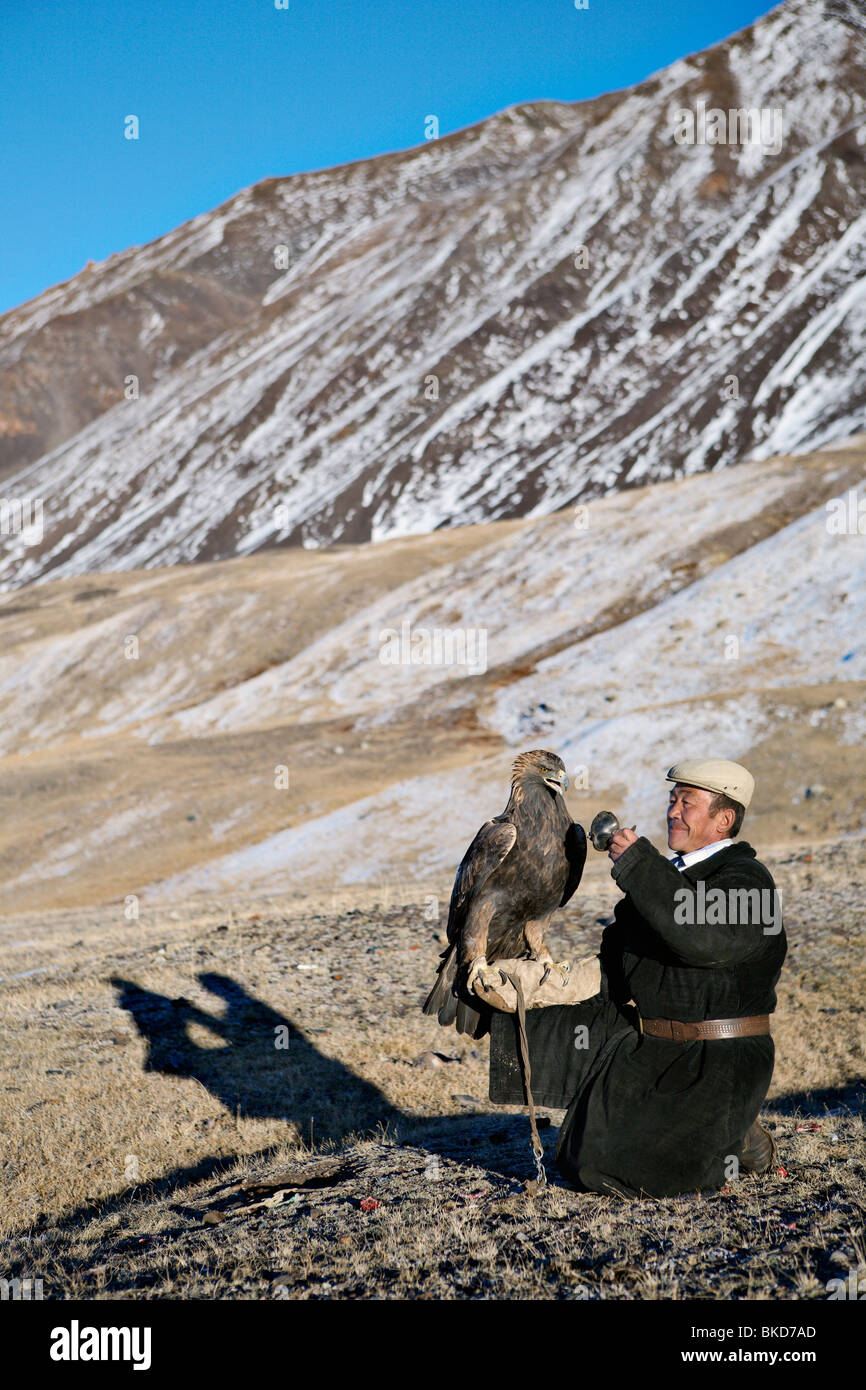 Trained hunting eagle and local Kazakh fur hunter in Western Mongolia. Stock Photo