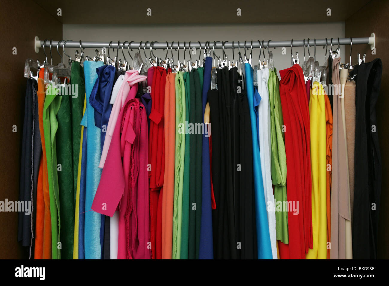 Colorful clothes hanging in store rack. Stock Photo