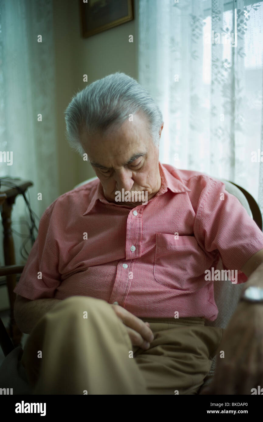 Old man sleeping in living room chair Stock Photo