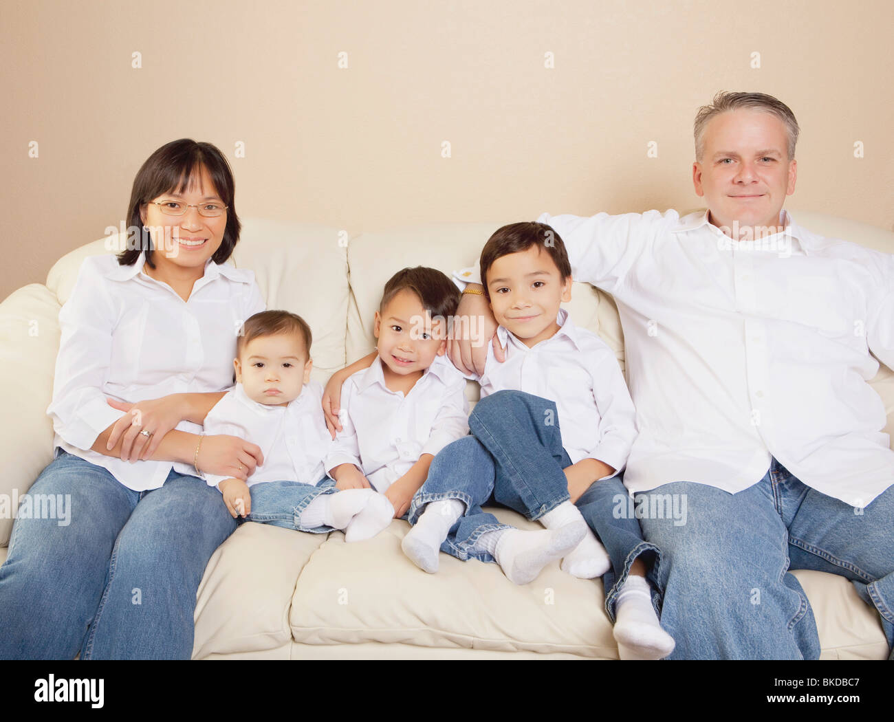 Family Sitting On A Couch Stock Photo - Alamy