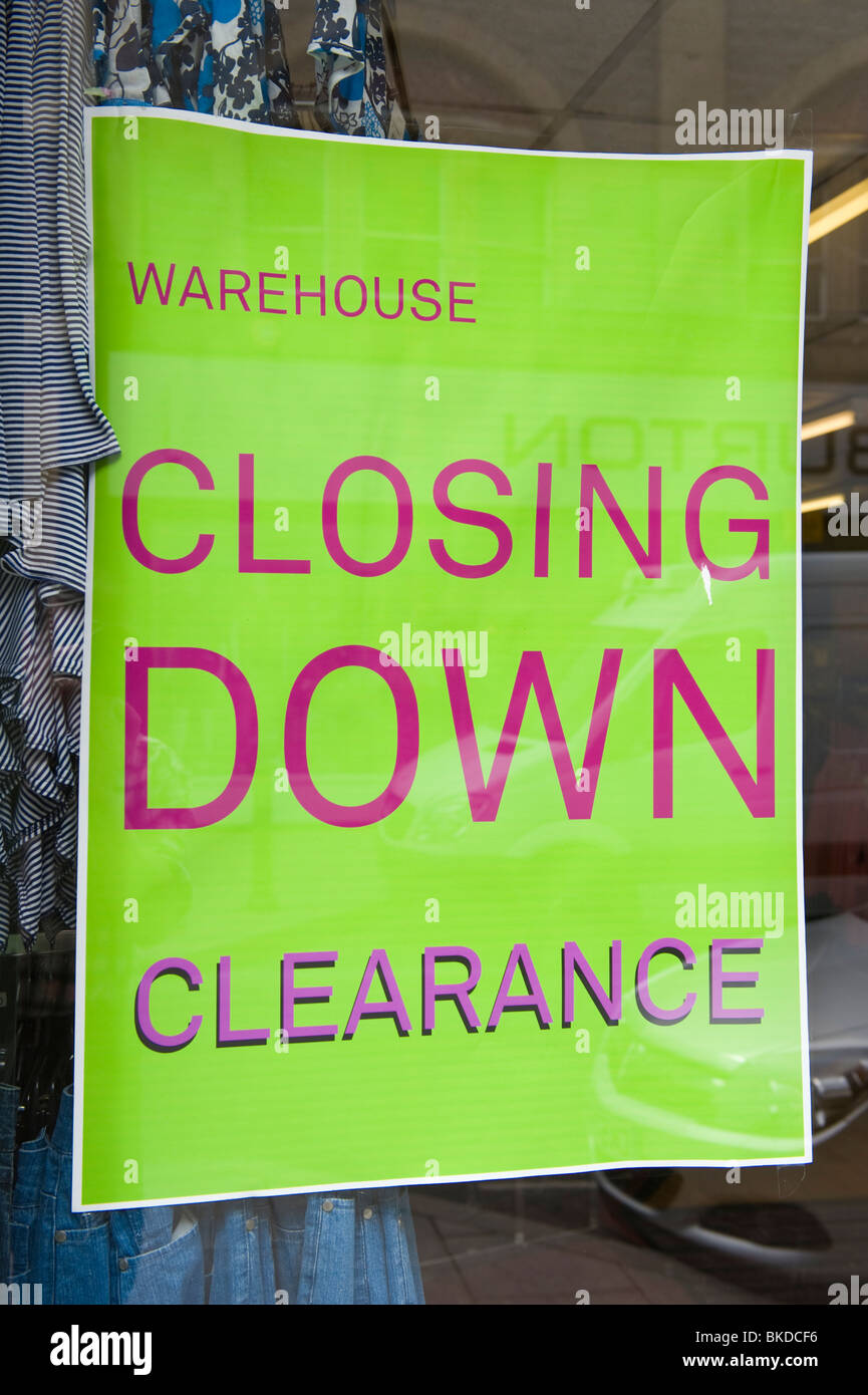 Warehouse CLOSING DOWN clearance sale sign in window of clothes store
