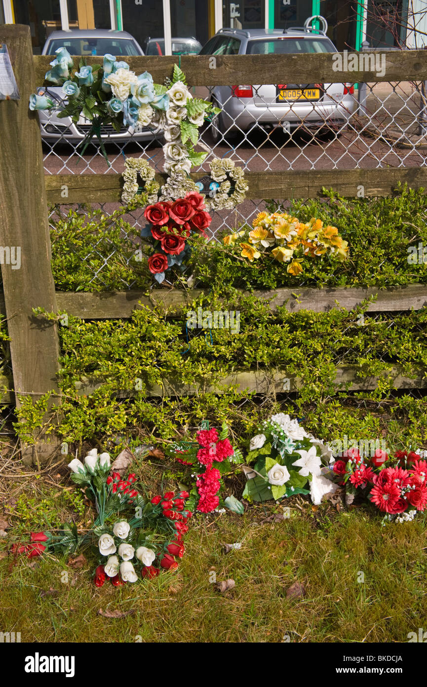 Roadside memorial at scene of fatal accident bunches of plastic flowers tied to fence Abertillery Blaenau Gwent South Wales UK Stock Photo