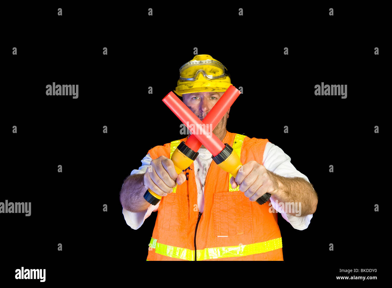 A construction worker uses flashlight signaling devices to communicate ...
