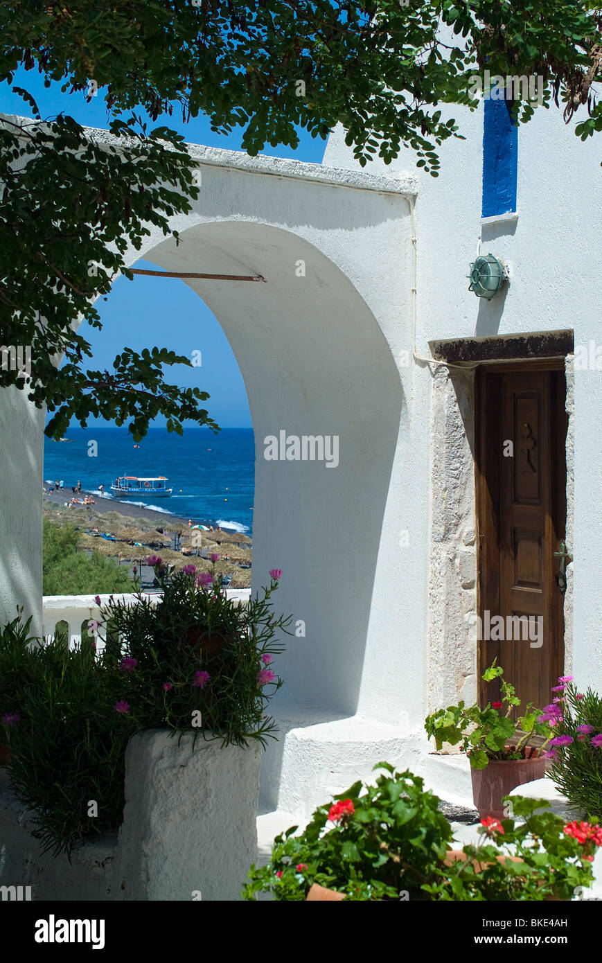 Church Arch with flowers overlooking Beach, Kamari, Santorini, Cyclades, Greece Stock Photo