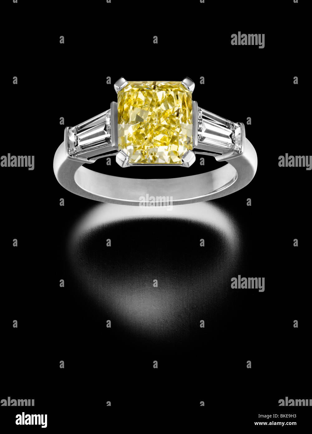 Large yellow diamond solitaire ring side baguettes Stock Photo