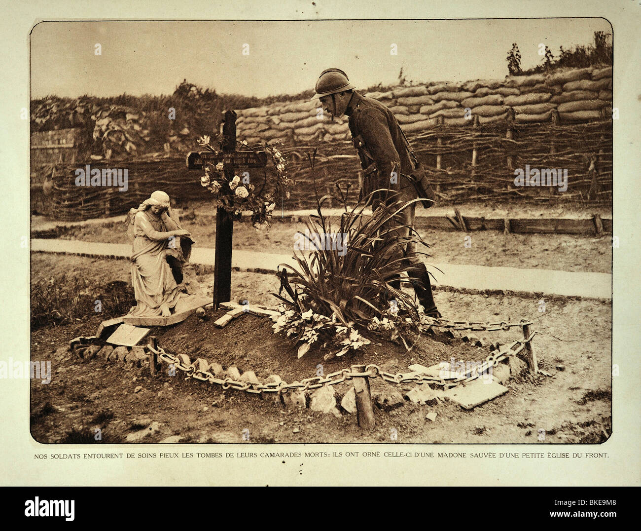 WWI Belgian soldier visiting temporary grave in trench in West Flanders during the First World War One, Belgium Stock Photo