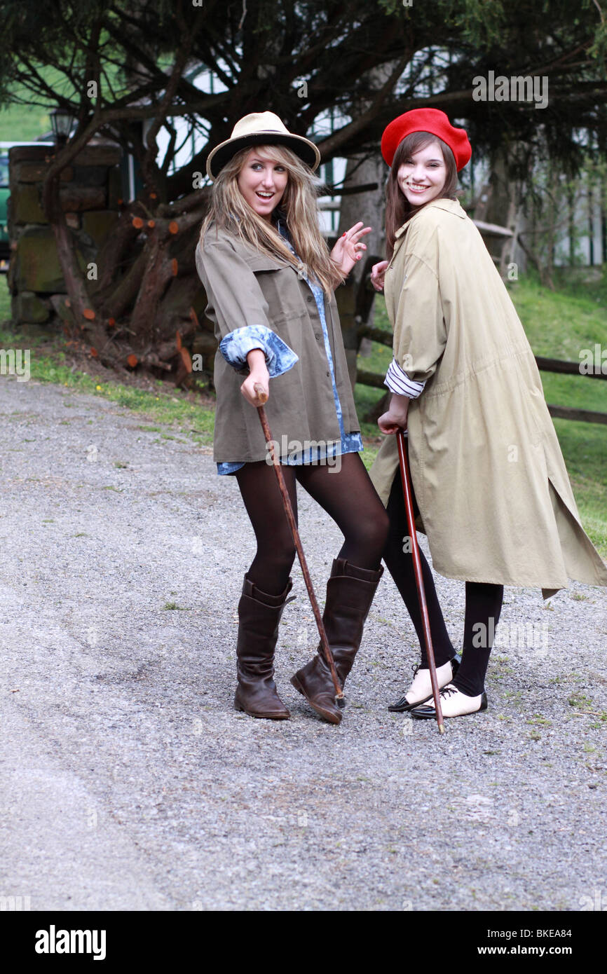 two stylish trendy fashionable young ladies dancing singing with canes