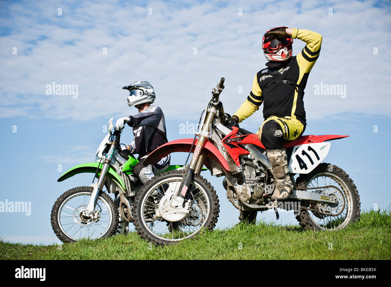 Two Adult male dirtbike riders take a break from riding Stock Photo