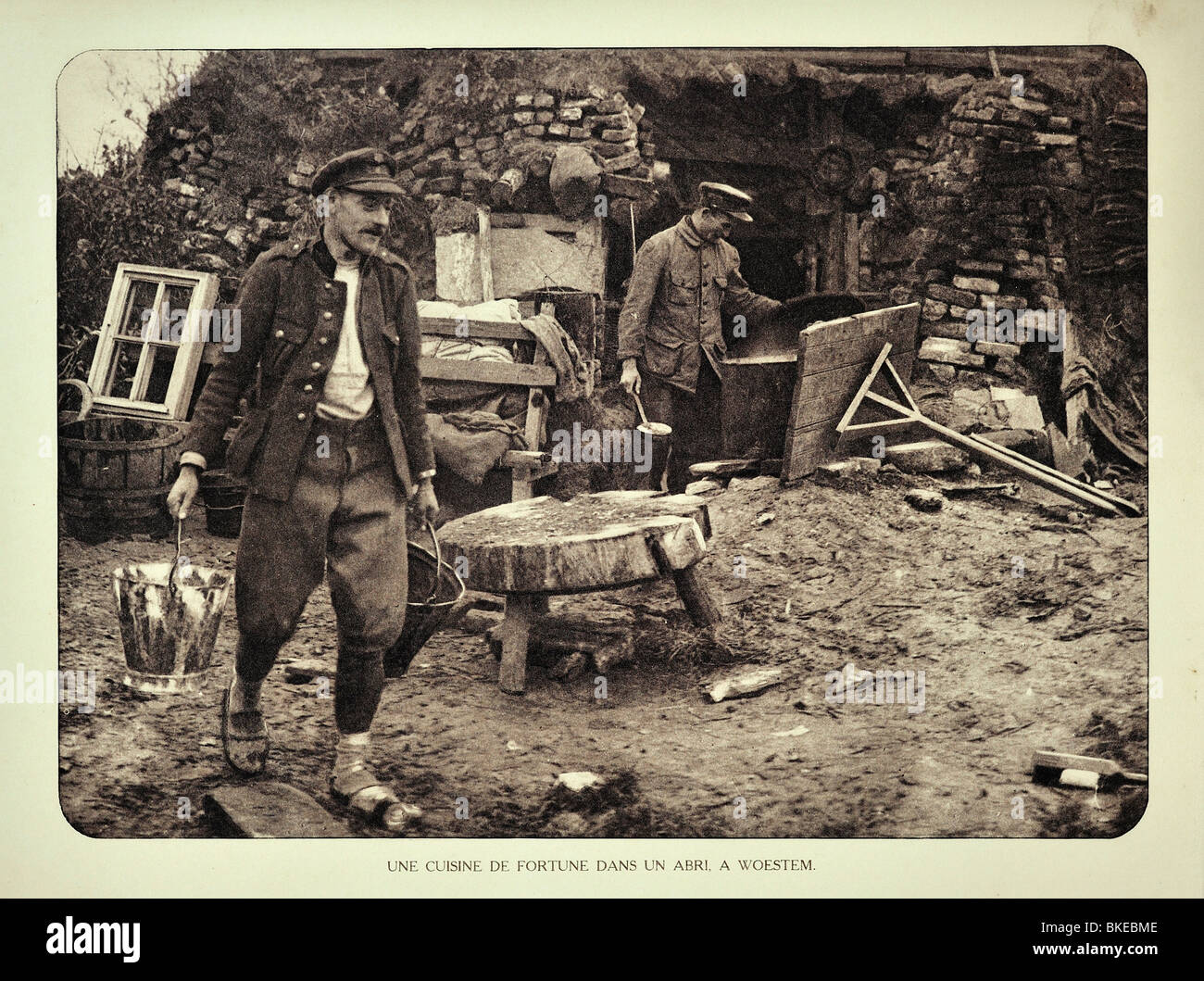 WWI soldiers preparing food in field kitchen outside shelter at Woesten