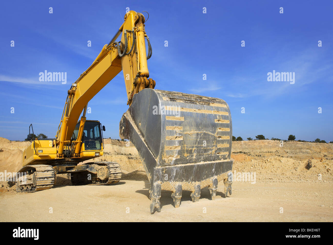 excavator yellow vehicle sand quarry outdoor blue sky Stock Photo - Alamy