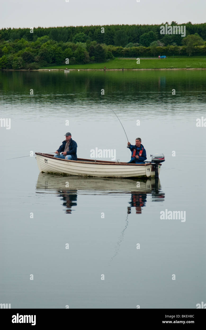 Two fishermen in a boat on Draycote Water, Warwickshire, UK. Stock Photo