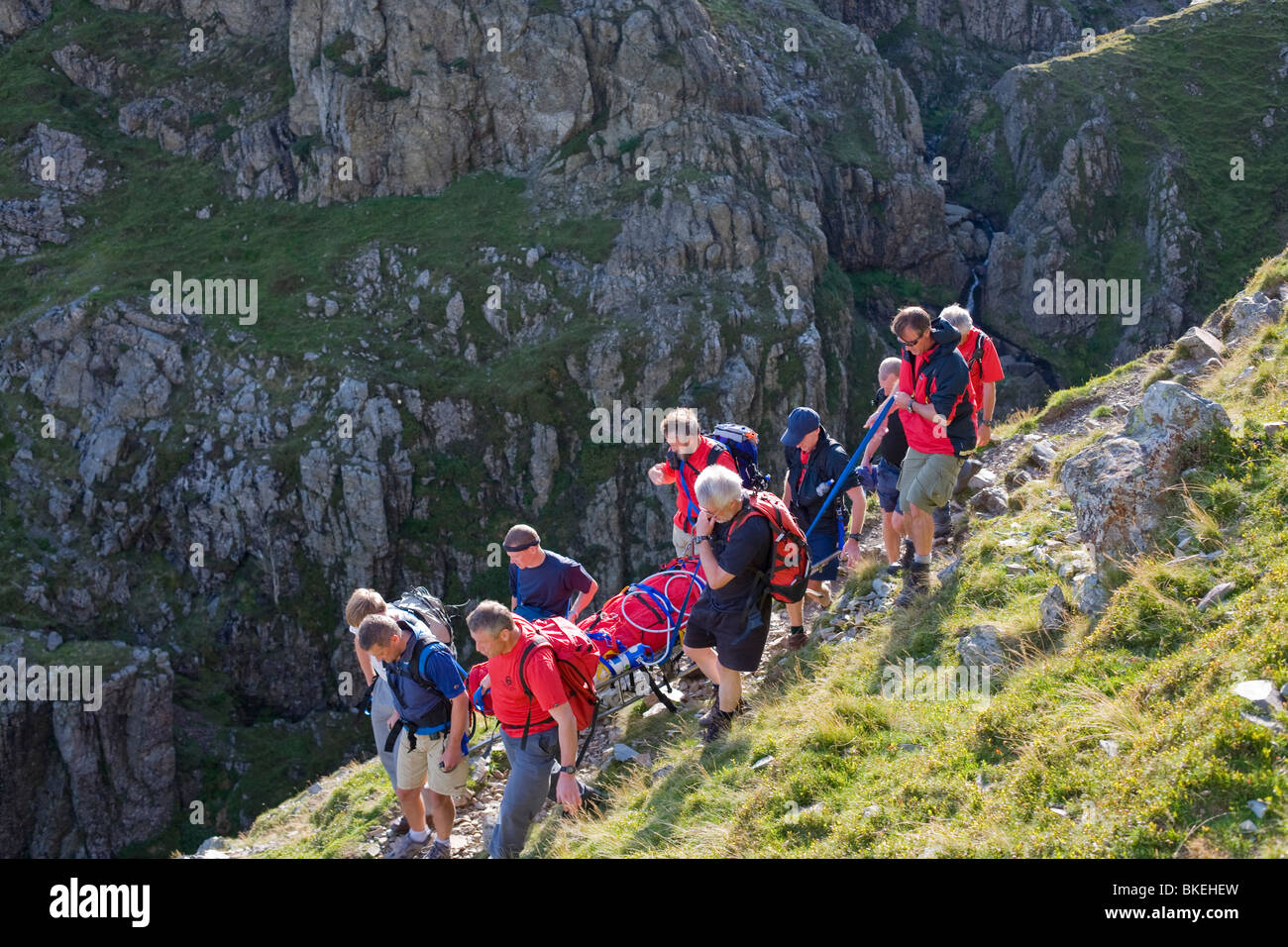 Members of Langdale Ambleside Mountain Rescue Team carrying an injured walker from the fells in Langdale Cumbria UK Stock Photo