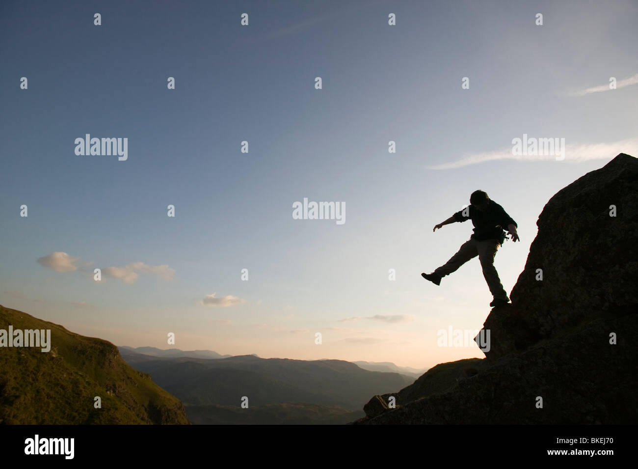 A climber balancing on a crag above Thirlmere in the Lake District UK Stock Photo