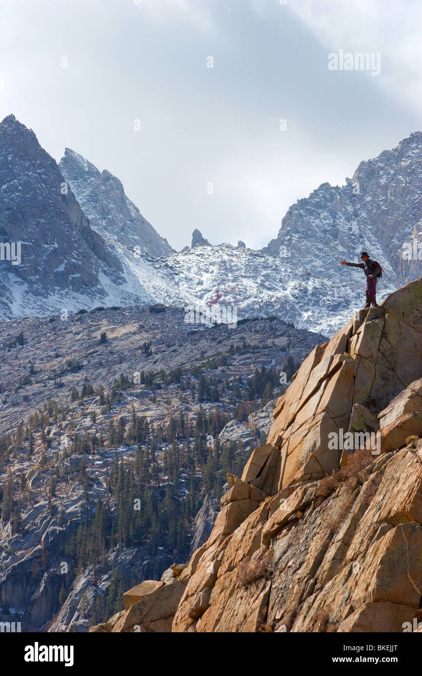 Distant view of a mountain climber in the High Sierras throwing his ...