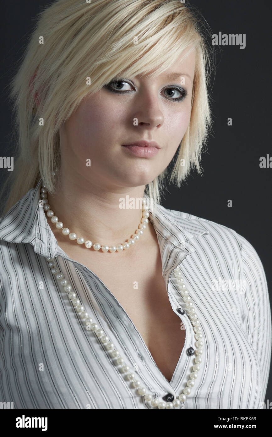 Young pale skinned woman with short blonde hair and white formal striped shirt Stock Photo