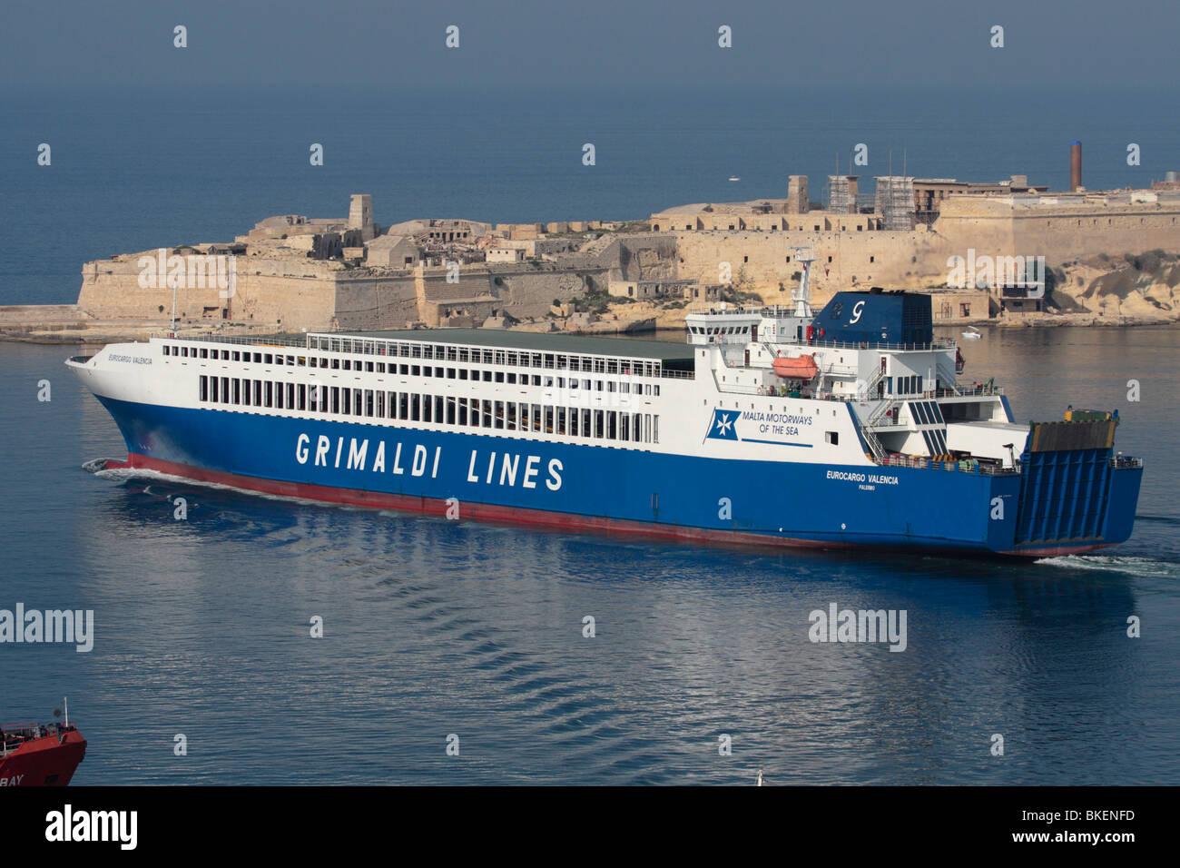 Commercial sea transport. The Grimaldi Lines ro-ro ferry Eurocargo Valencia departing from Malta's Grand Harbour, with Fort Ricasoli in the background Stock Photo