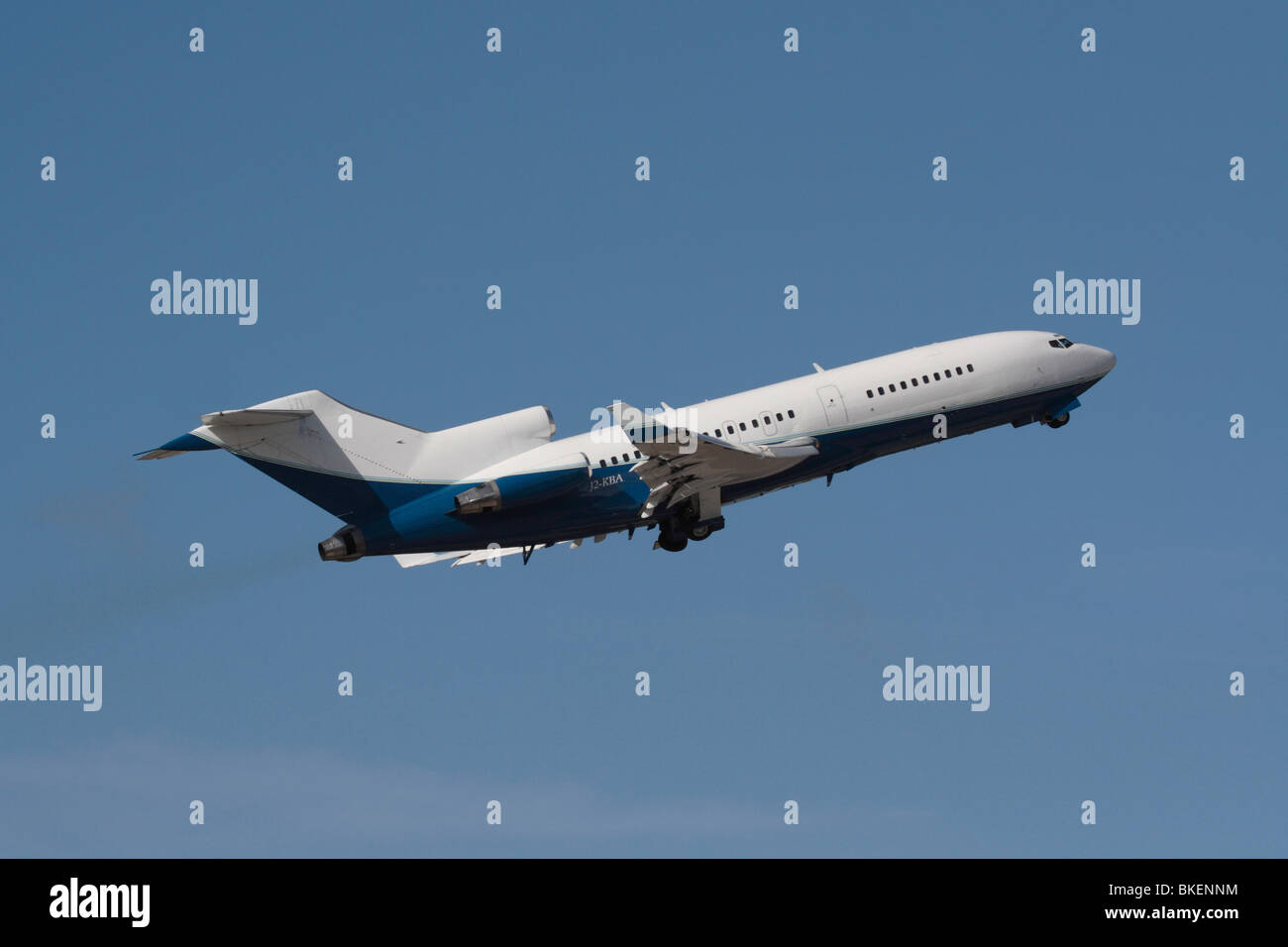 Boeing 727 commercial passenger jet plane flying in the air on takeoff against a blue sky Stock Photo