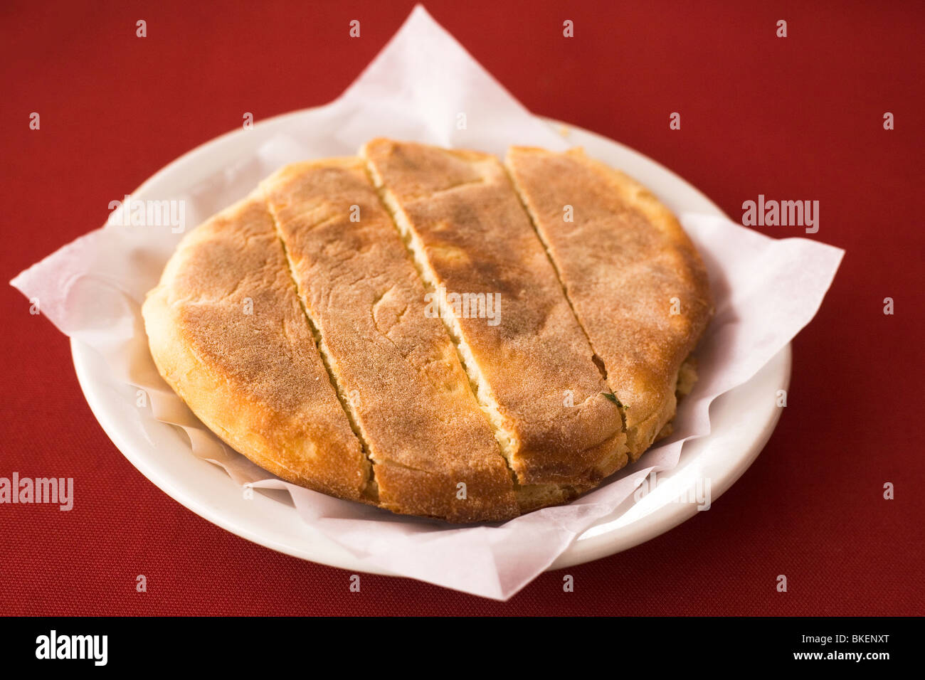 Traditional Madeiran flat bread, Bolo do caco, is served as garlic bread in a cafe in Funchal, Madeira. Stock Photo