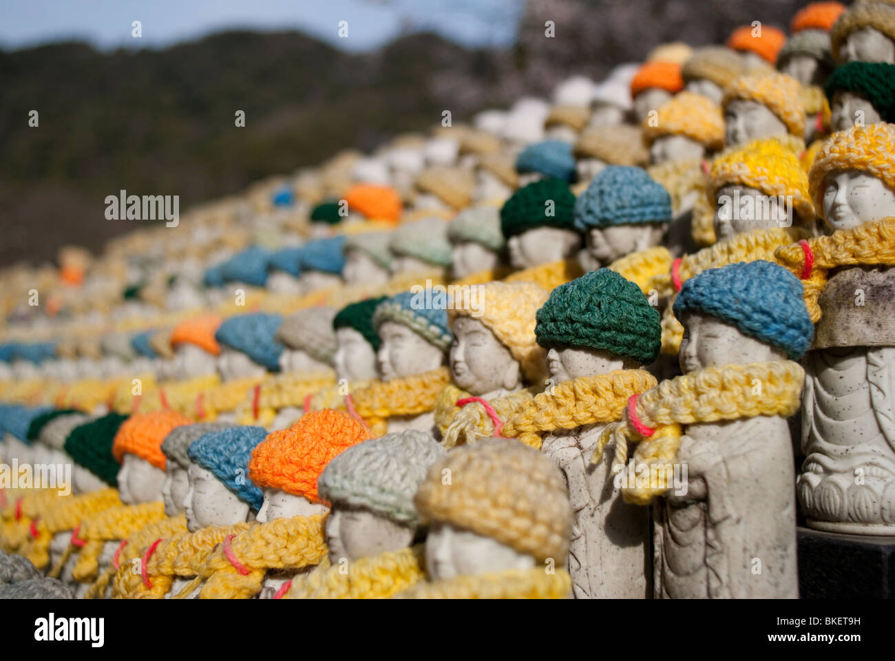 Rows of small Buddhist statues wearing woolen scarves and hats at Hase