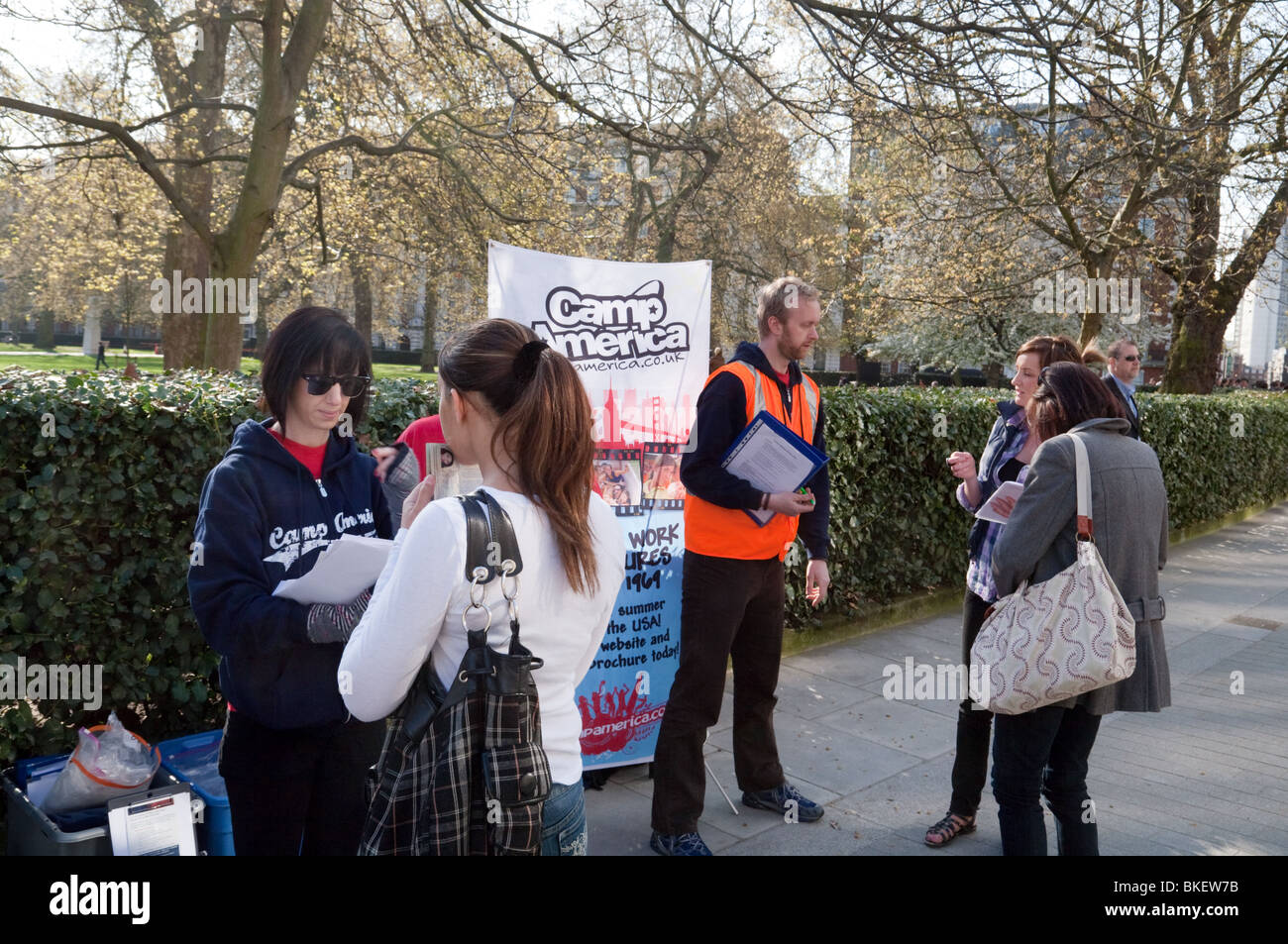 Teenagers queuing to register for Camp America outside the US embassy, Grosvenor Square, London UK Stock Photo