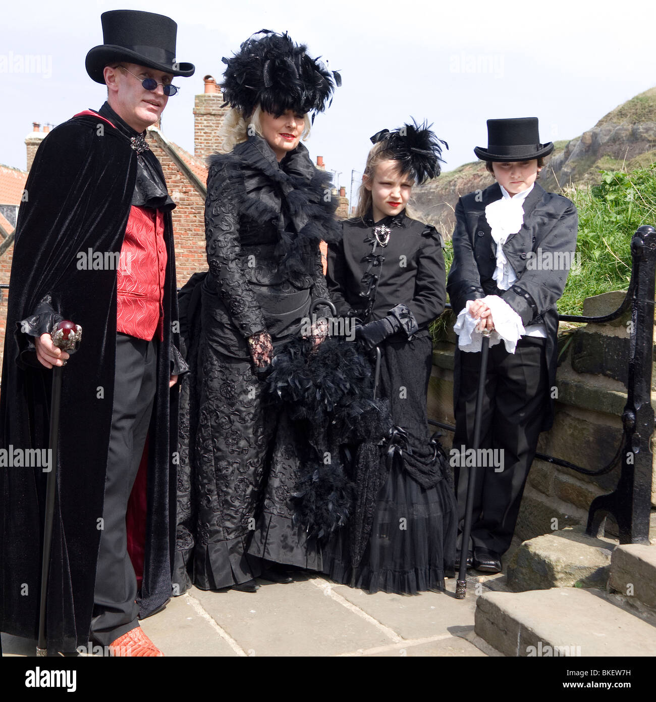 A man woman and two children in fancy dress pose on the famous 199 steps at the biannual Goth festival in Whitby Stock Photo