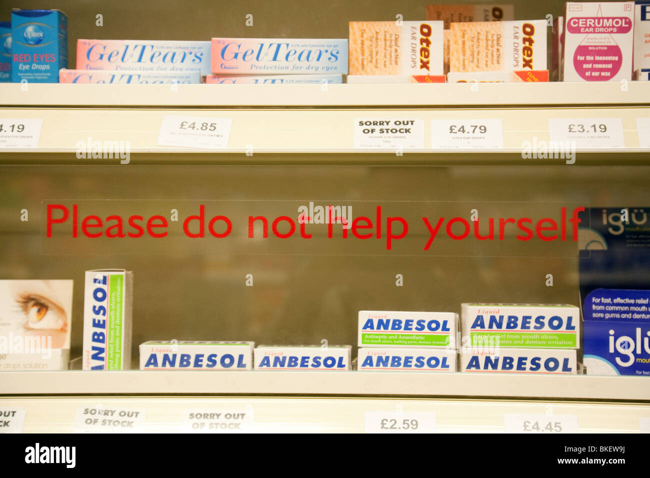 Sign on a shelf in a chemist saying 'Do not help yourself';  London UK Stock Photo