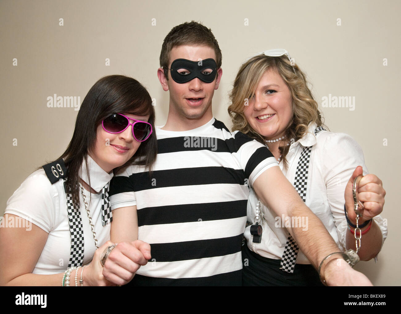Teenagers dressed up to go to a cops and robbers fancy dress party, UK Stock Photo