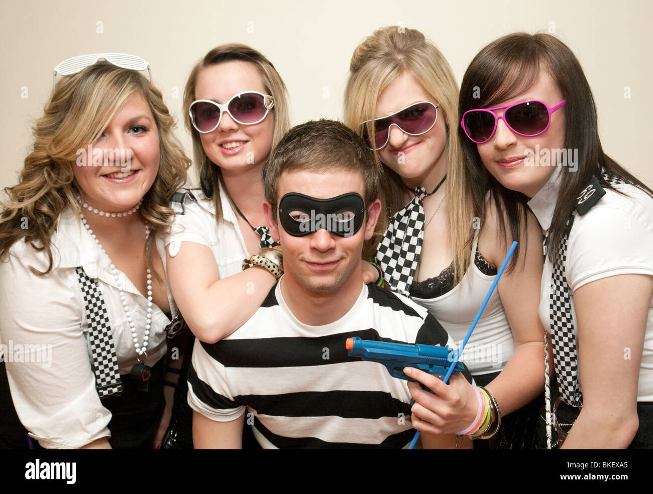 Teenagers dressed up to go to a cops and robbers fancy dress party, UK Stock Photo