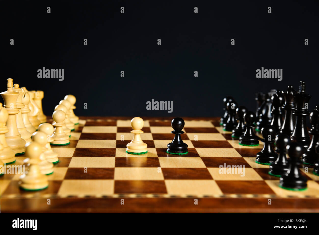 Close up of chess pieces on wooden chessboard Stock Photo