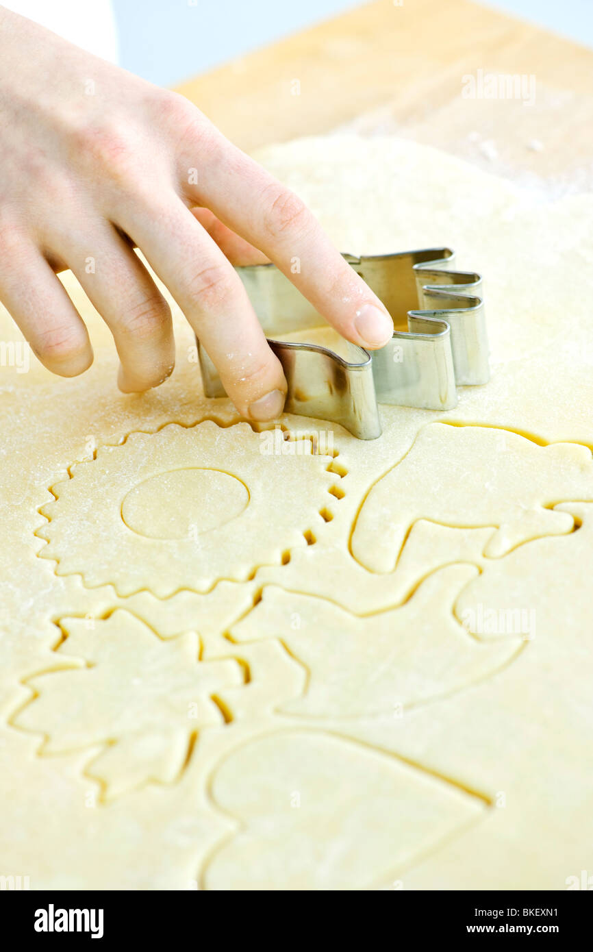 Cutting cookie shapes in rolled dough with cutter Stock Photo