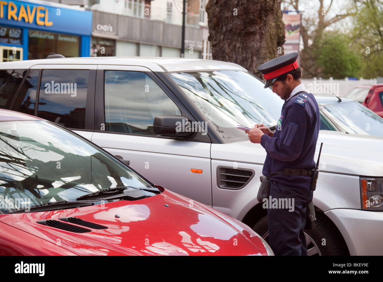 A traffic warden writing out a ticket for a car, Chislehurst, SE London