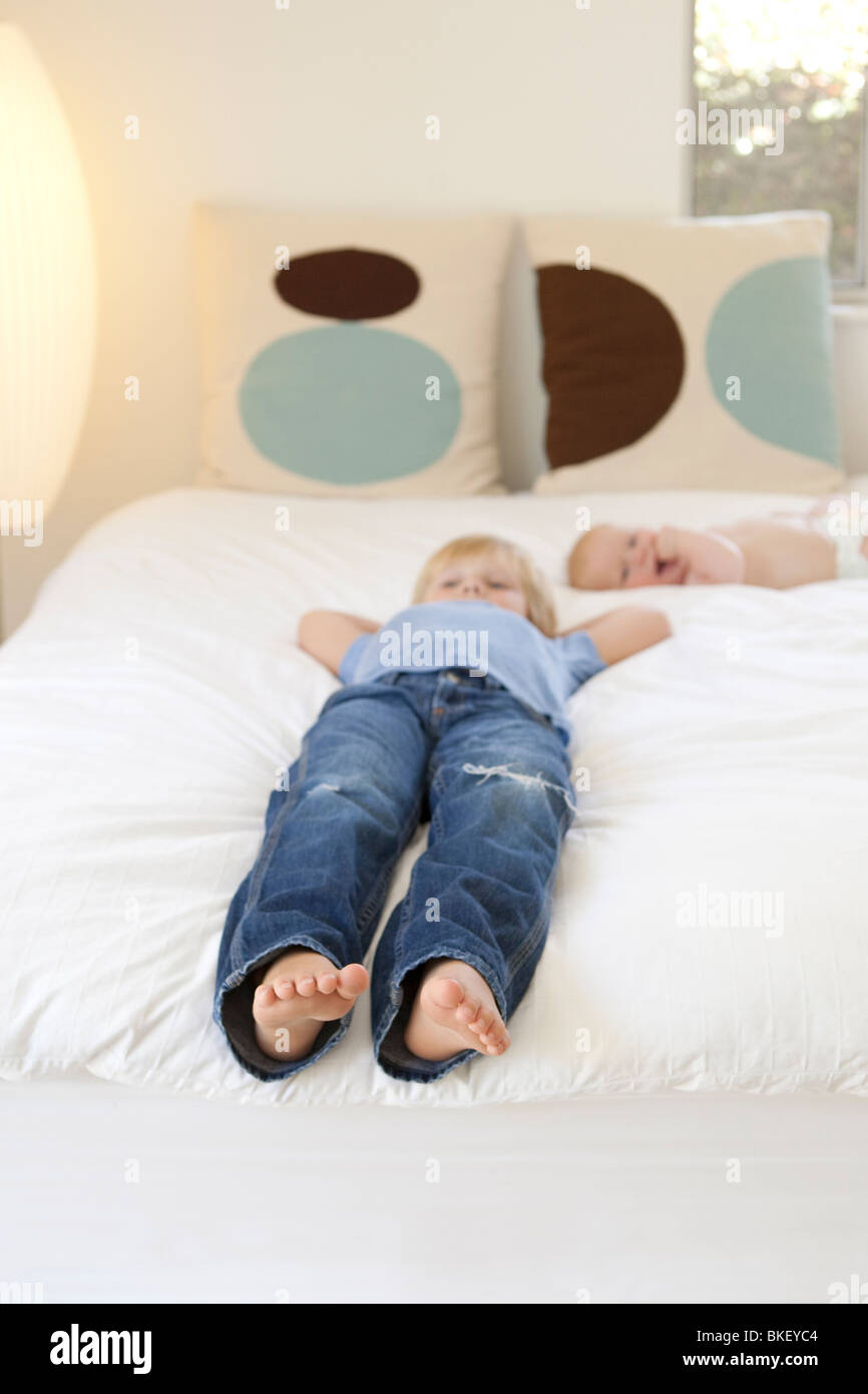 Boys relaxing on bed Stock Photo